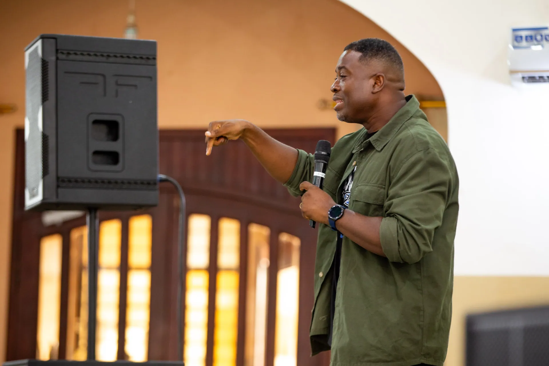 A guest speaker teaching with a microphone at Faith Camp