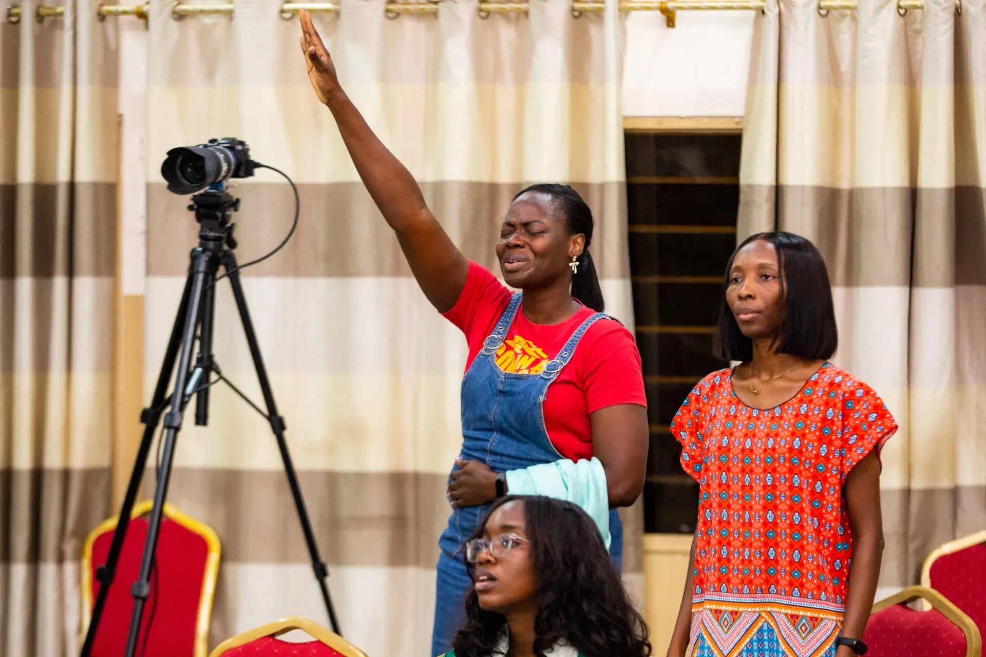 A woman worshipping with her hand raised at Faith Camp