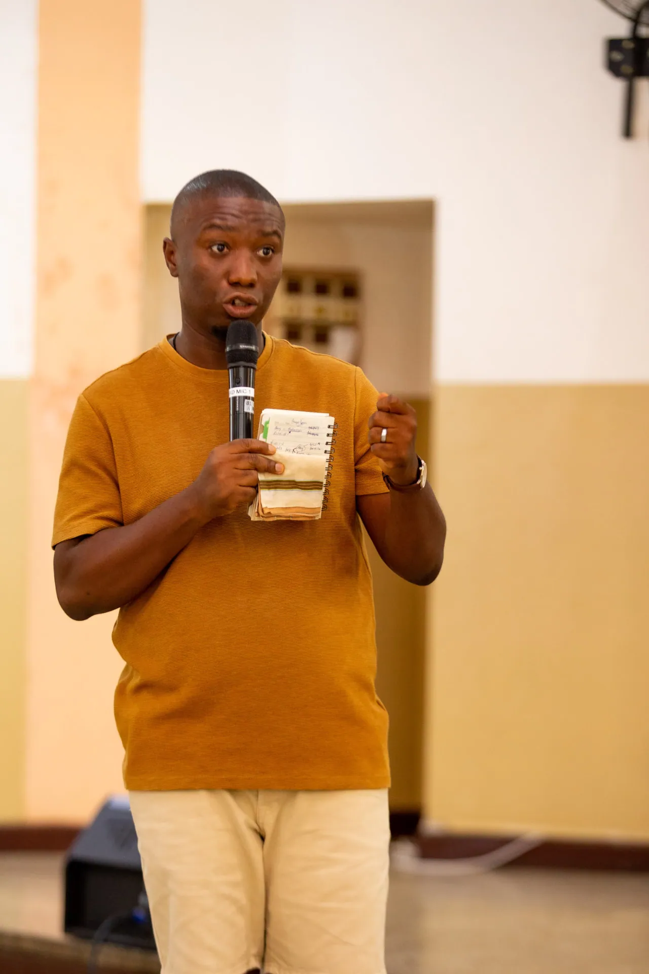 A member teaching from his notes with a microphone at Faith Camp