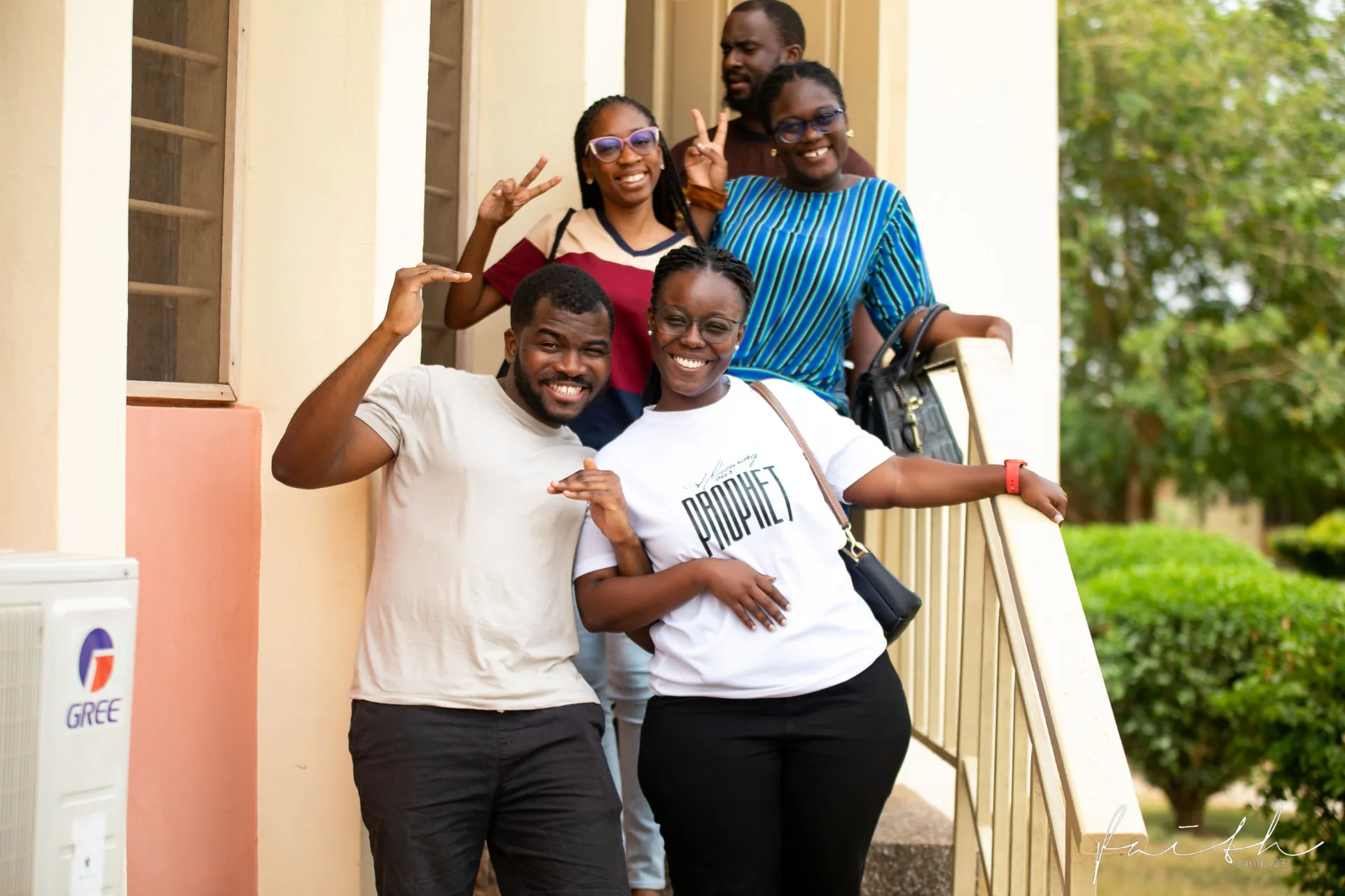A group of friends laughing on the steps at Faith Camp